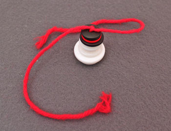 Button and yarn snowman step 5 tie knot above last button