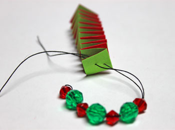 Catstep Braid and Bead Ornament step 13 push thread through holes in end of paper