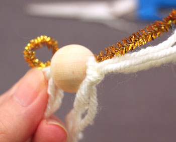 Easy Angel Crafts Tulle Angel step 6 tie a knot in the yarns below the wooden bead